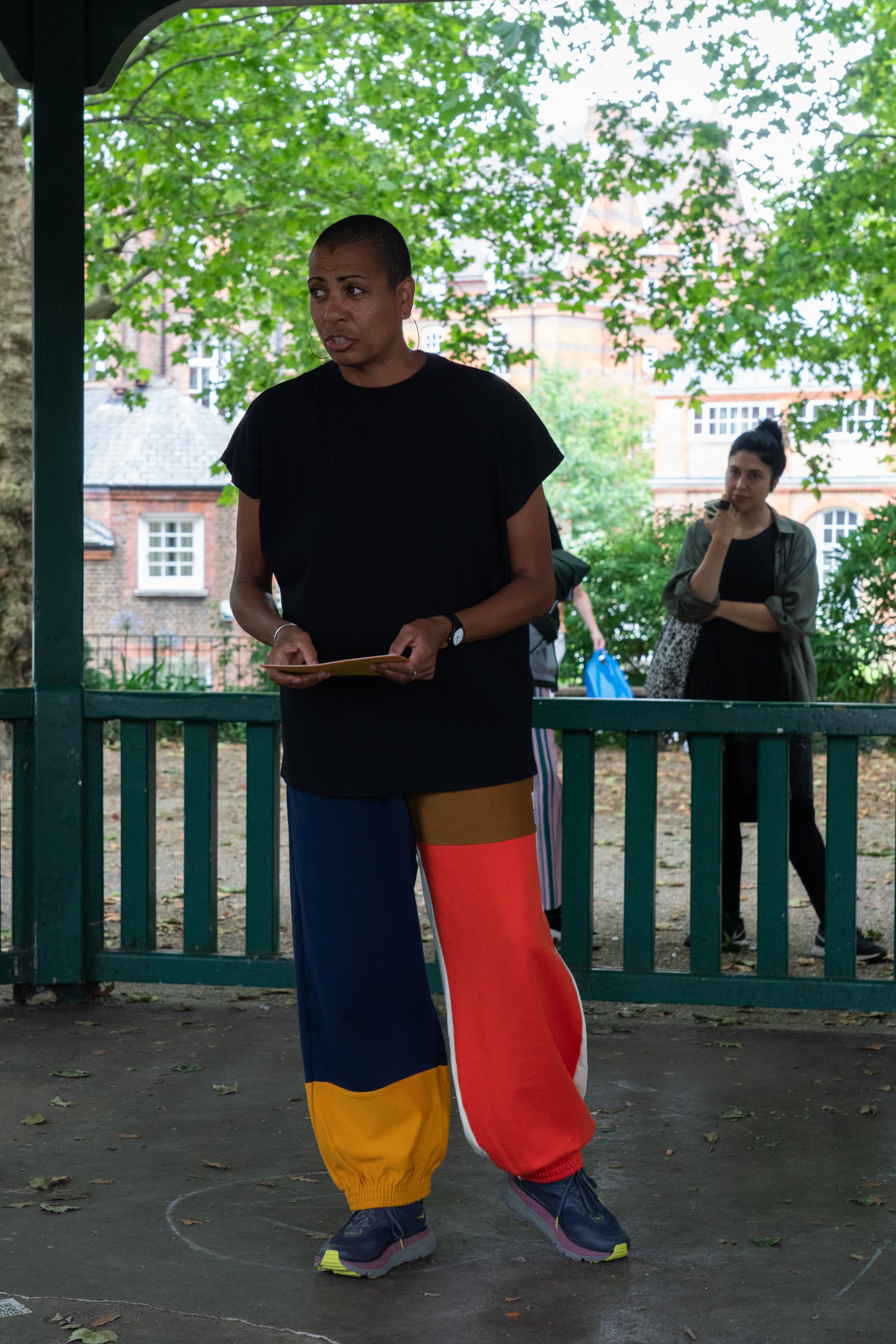 The artist Helen Cammock giving a reading of one of her perfomances. In the background is a poster that says I can hear your lament