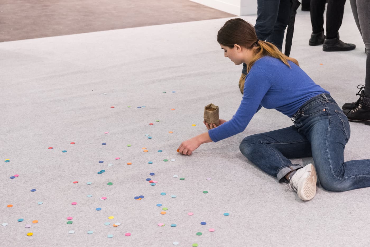 A performer sitting on the floor arranging pieces of confetti