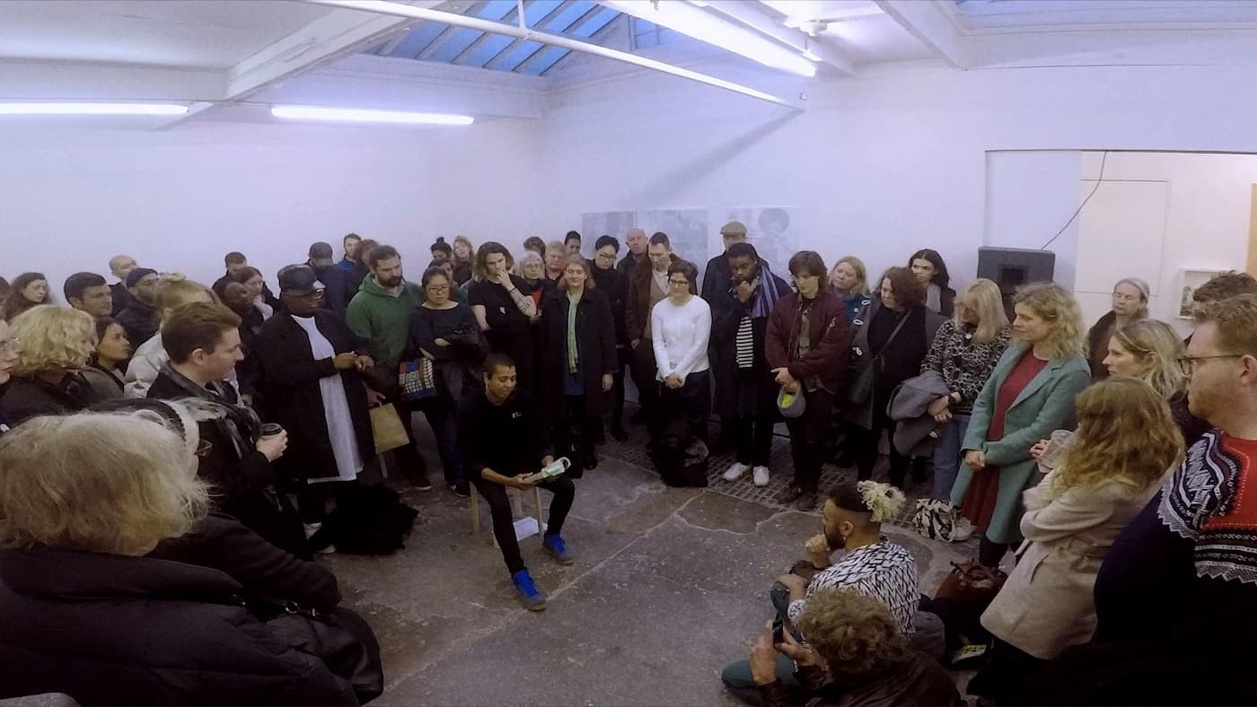 The artist Helen Cammock sat, giving a performance of Freedom Song, to a room full of people.